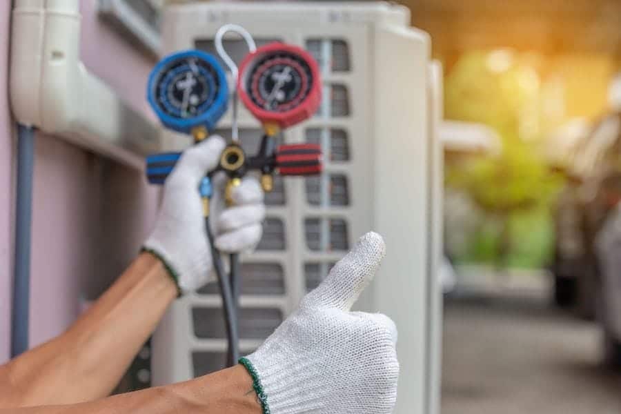 Image of someone holding a gauge and giving a thumbs up. What Does an HVAC Maintenance Inspection Include.