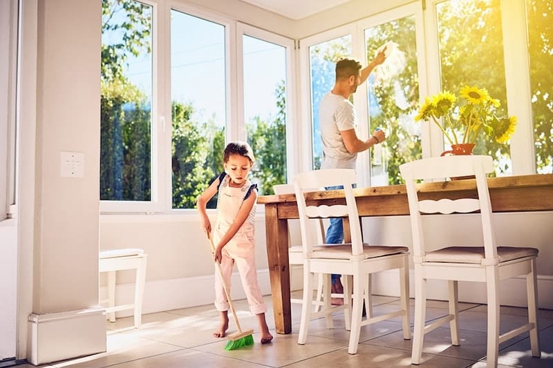 Father and daughter cleaning their home after learning how environmental issues can affect their AC system.