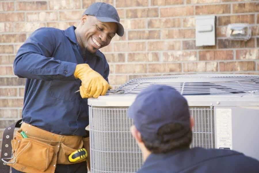 Image of technicians working on ac unit. Why Schedule Air Conditioning Maintenance?