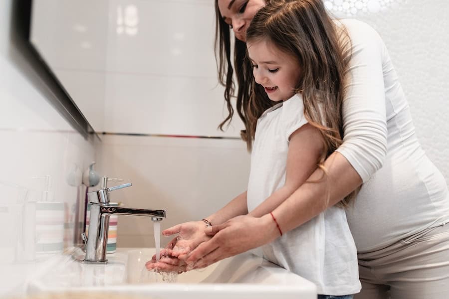 Kid washing hands at home as part of the HVAC FAQ for COVID-19.