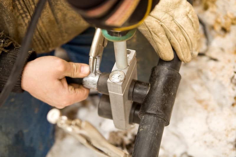 Two Workers Join Residential Geothermal Heating/Cooling Pipe.